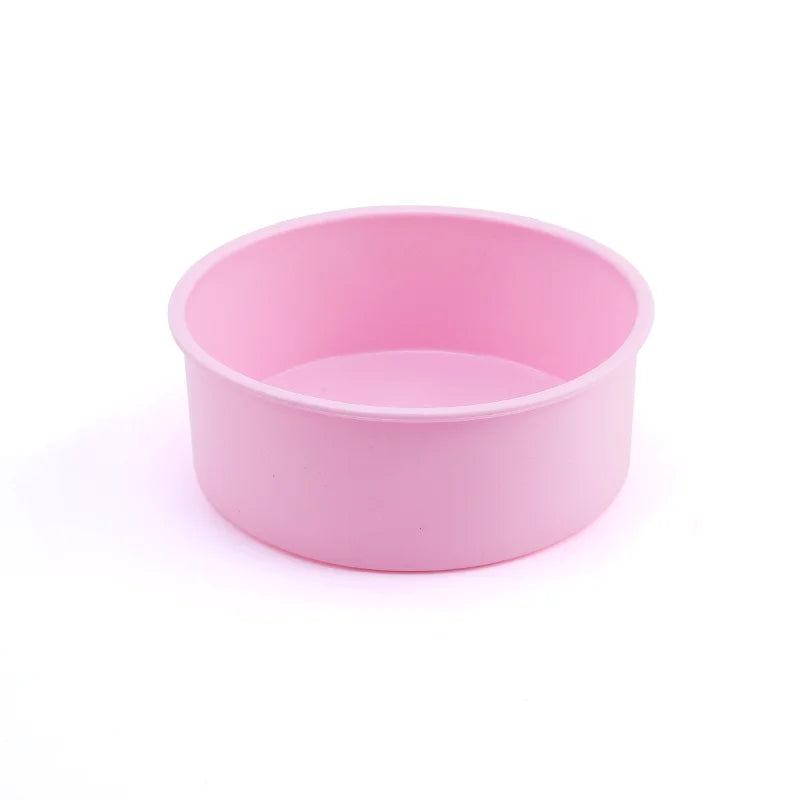 Un moule rond en silicone de couleur rose pale, concu pour les patisseries et gateaux.