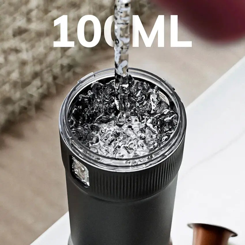 Un récipient noir est rempli avec de l'eau, avec l'indication "100 ML" visible en haut.
