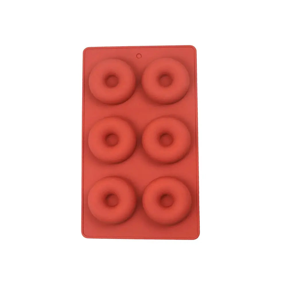 Moule en silicone rouge avec six cavités circulaires pour la cuisson de donuts maison.